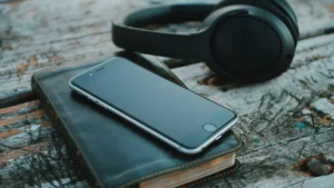 本の上に置いたスマートフォンとヘッドホン