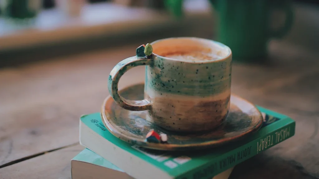 窓辺の本に添えられたコーヒーカップ